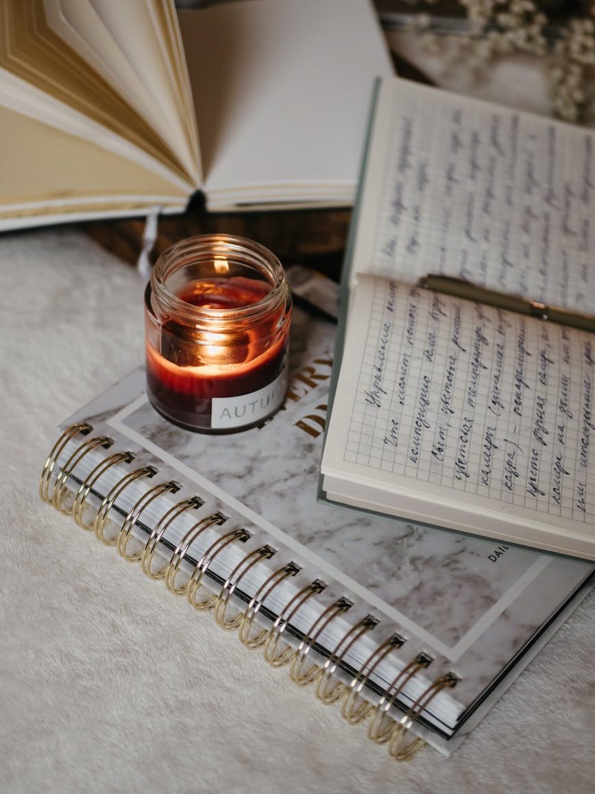 a diary beside a lit candle