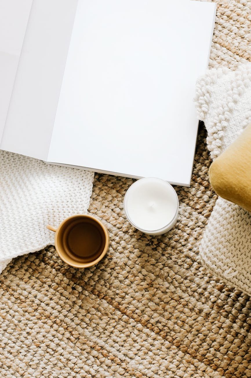 opened diary placed on table near mug and candle